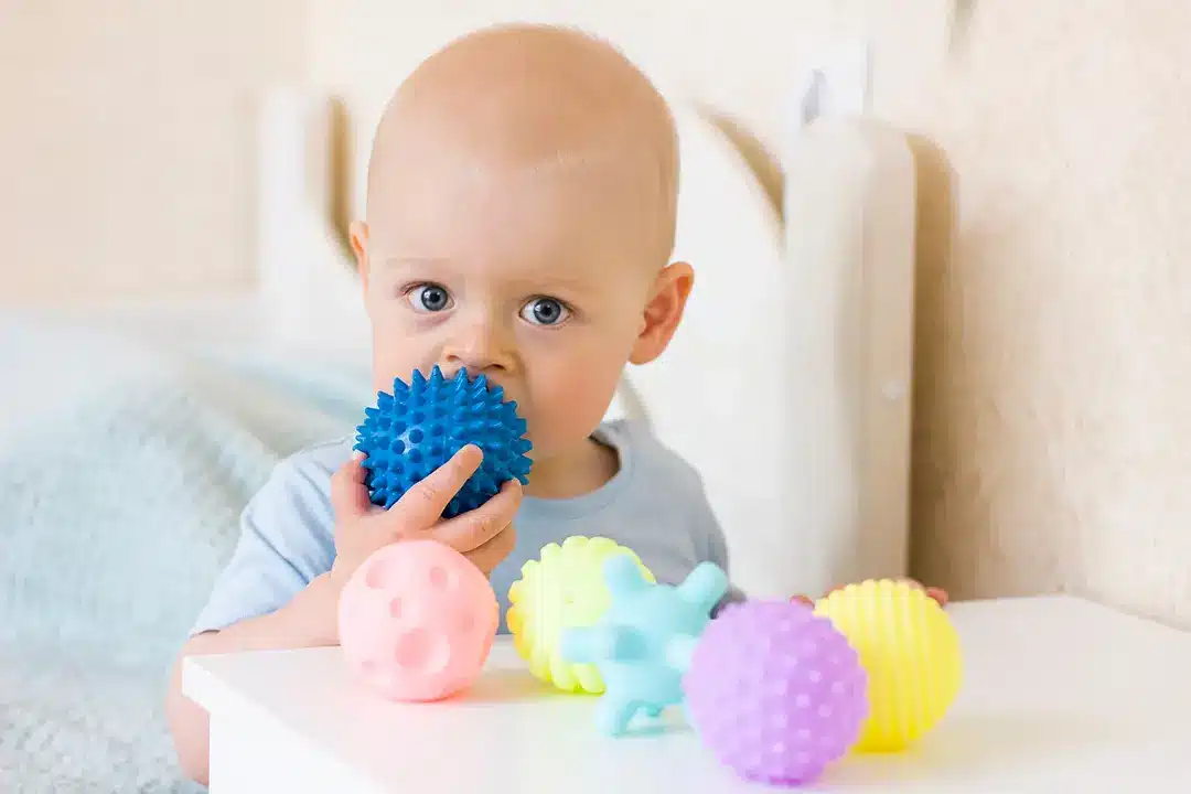 Montessori-Spiele was ist das? 4 Montessori was ist das? Kind mit sensorischen Bällen