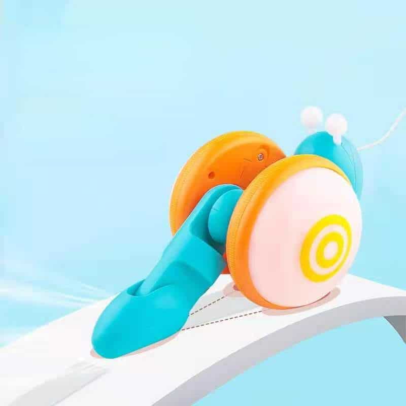 Nachziehspiel - Musikalische Schnecke Ein Ziehspiel - Musikalische Schnecke rollt über eine weiße Fläche.