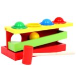 Holzhammerspiel in 4 Farben mit Kugeln und einem Hammer.