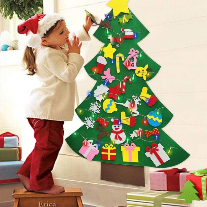 Ein Mädchen steht neben einem festlichen Weihnachtsbaum aus Filz mit 26 dekorativen Teilen.