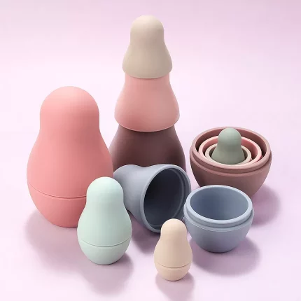Eine Gruppe von verschiedenfarbigen Plastikbehältern auf rosafarbenem Hintergrund.