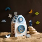 Eine Spielzeugrakete aus Holz im Sand.