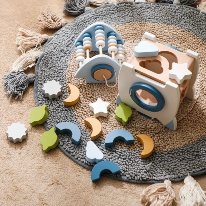 Ein Holzspielzeug mit Sternen und Monden auf einem Teppich.