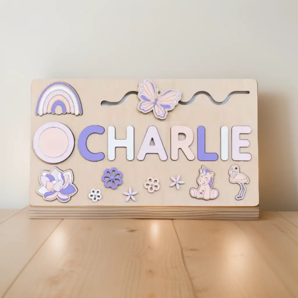 Namenspuzzle aus Holz mit dem Wort "CHARLIE" in Pastellfarben, verziert mit Formen wie einem Regenbogen, Schmetterling, Blume, Einhorn und Pilz auf einer Holzoberfläche.